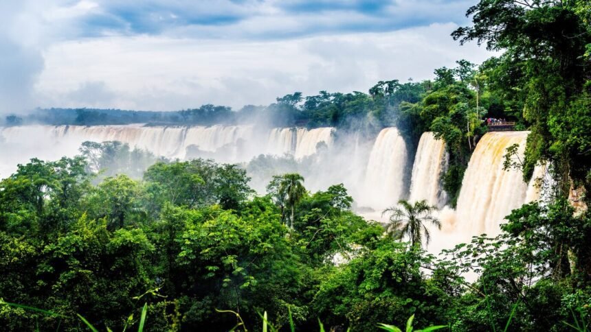 waterfall-iguazu-national-park-surrounded-by-forests-covered-fog-cloudy-sky_181624-17382